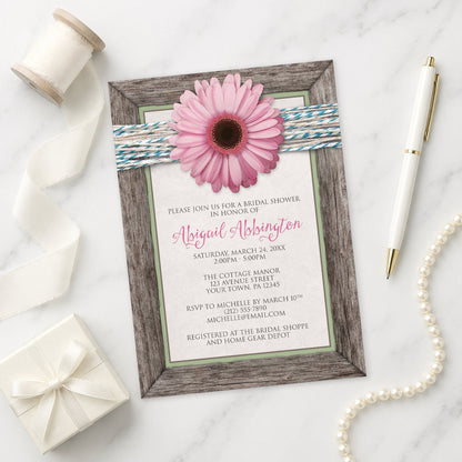 Rustic Pink Daisy Turquoise Wood Bridal Shower Invitation shown on a marble surface with a white gift box, pen, ribbon, and pearls.