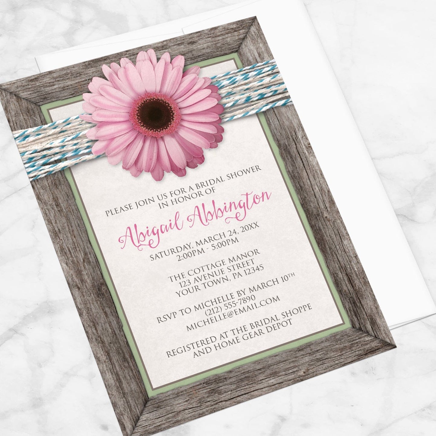 Rustic Pink Daisy Turquoise Wood Bridal Shower Invitation shown at an angle on a marble surface with a white envelope.