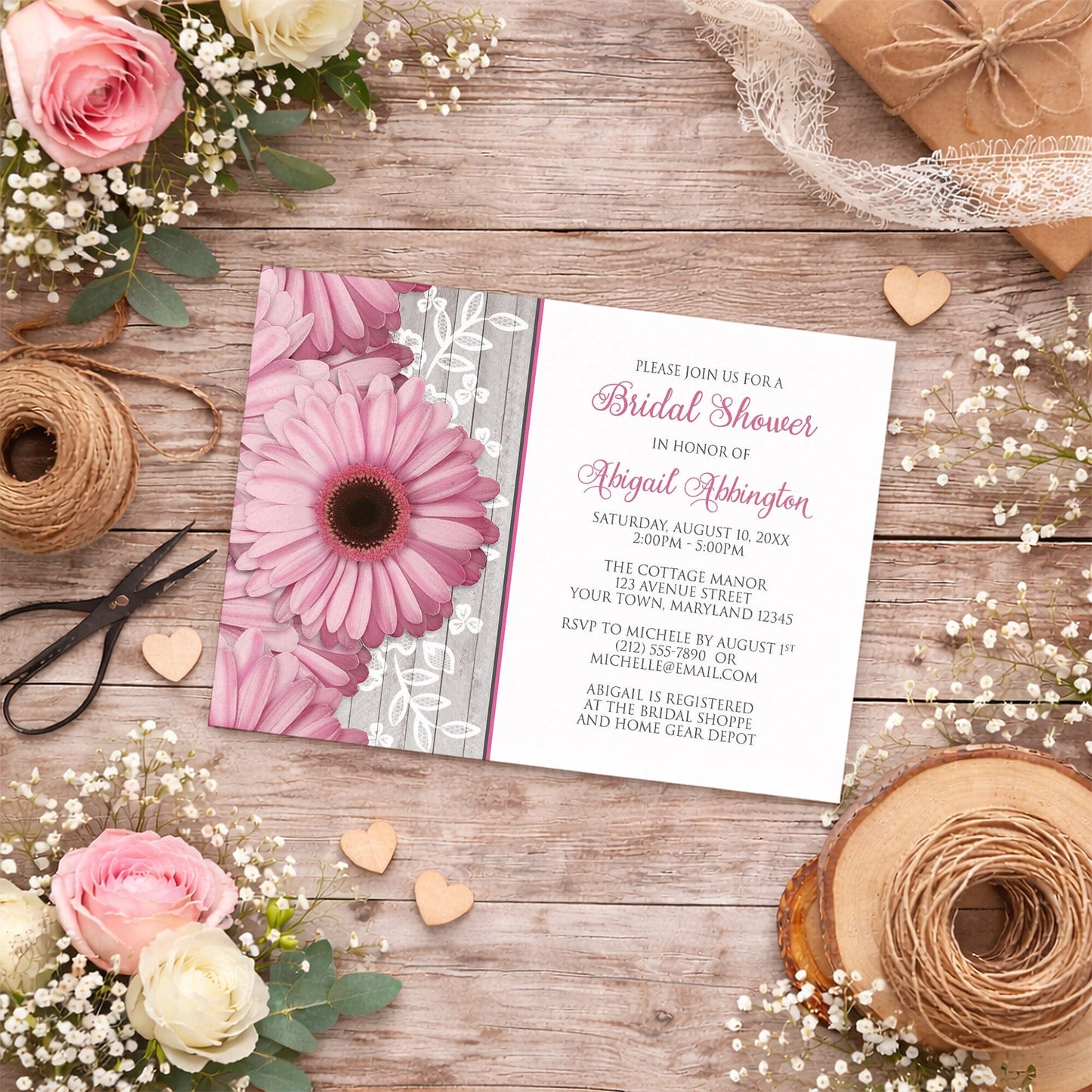 Rustic Pink Daisy Wood White Bridal Shower Invitation shown on a country wood surface with spring and summer flowers, small wood hearts, lace ribbon, and twine.