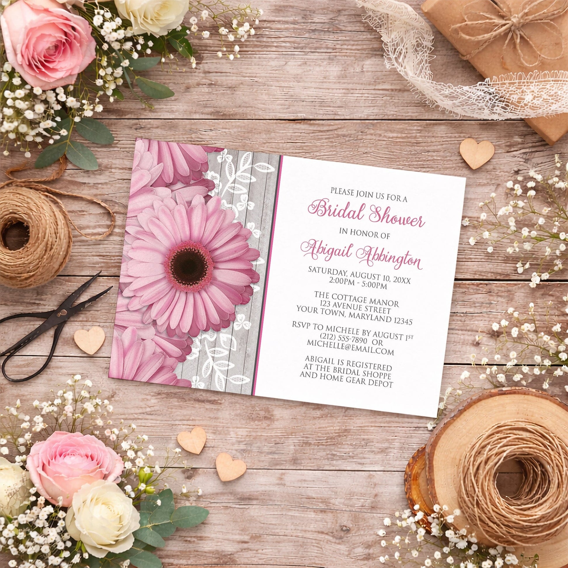 Rustic Pink Daisy Wood White Bridal Shower Invitation shown on a country wood surface with spring and summer flowers, small wood hearts, lace ribbon, and twine.