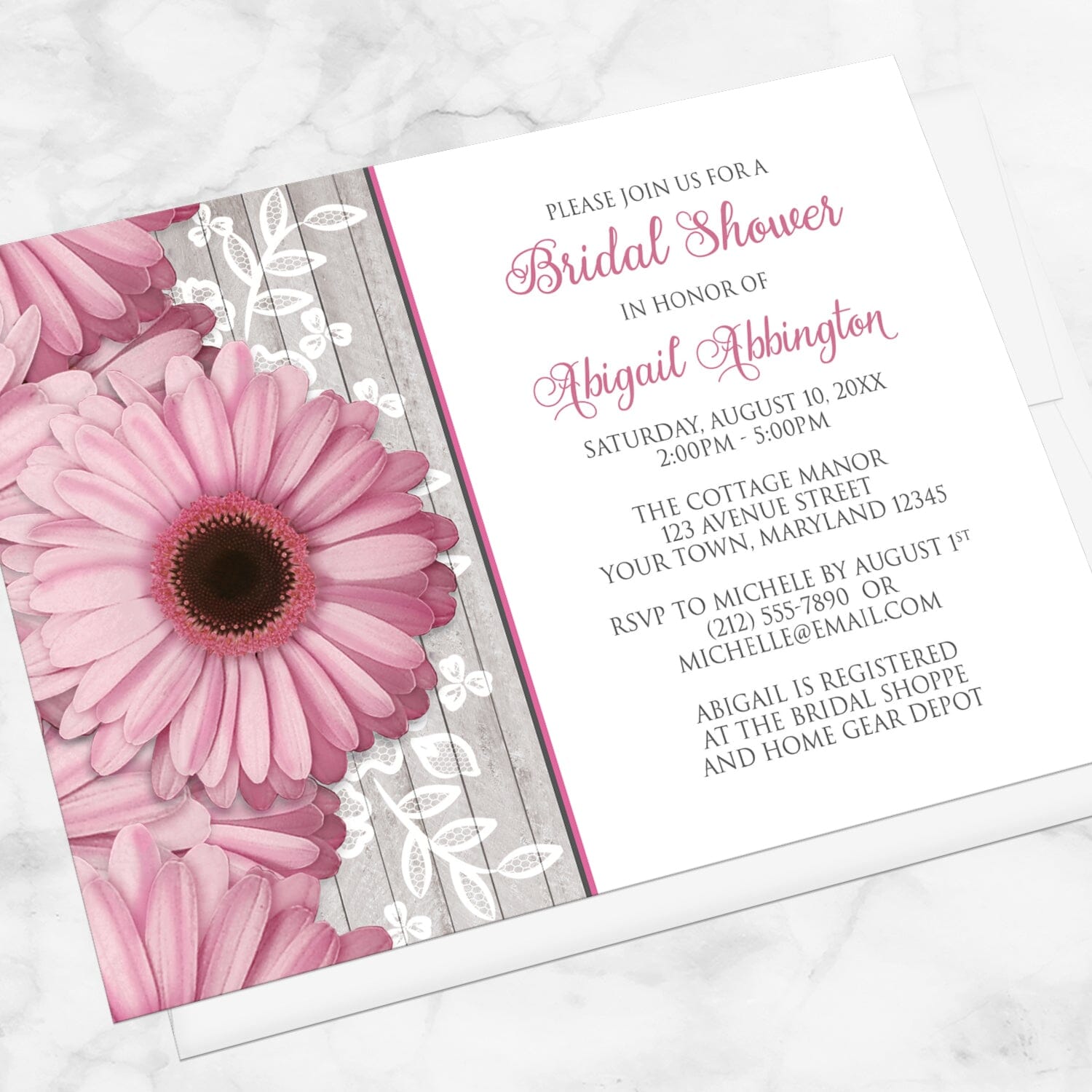 Rustic Pink Daisy Wood White Bridal Shower Invitation shown at an angle on a marble surface with a white envelope.