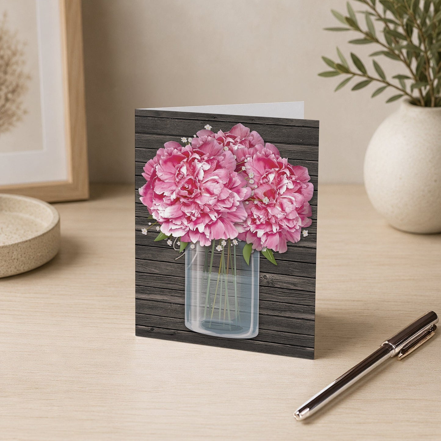 Rustic Pink Peony Wood Mason Jar Note Card shown on a desk with a vase and pen.