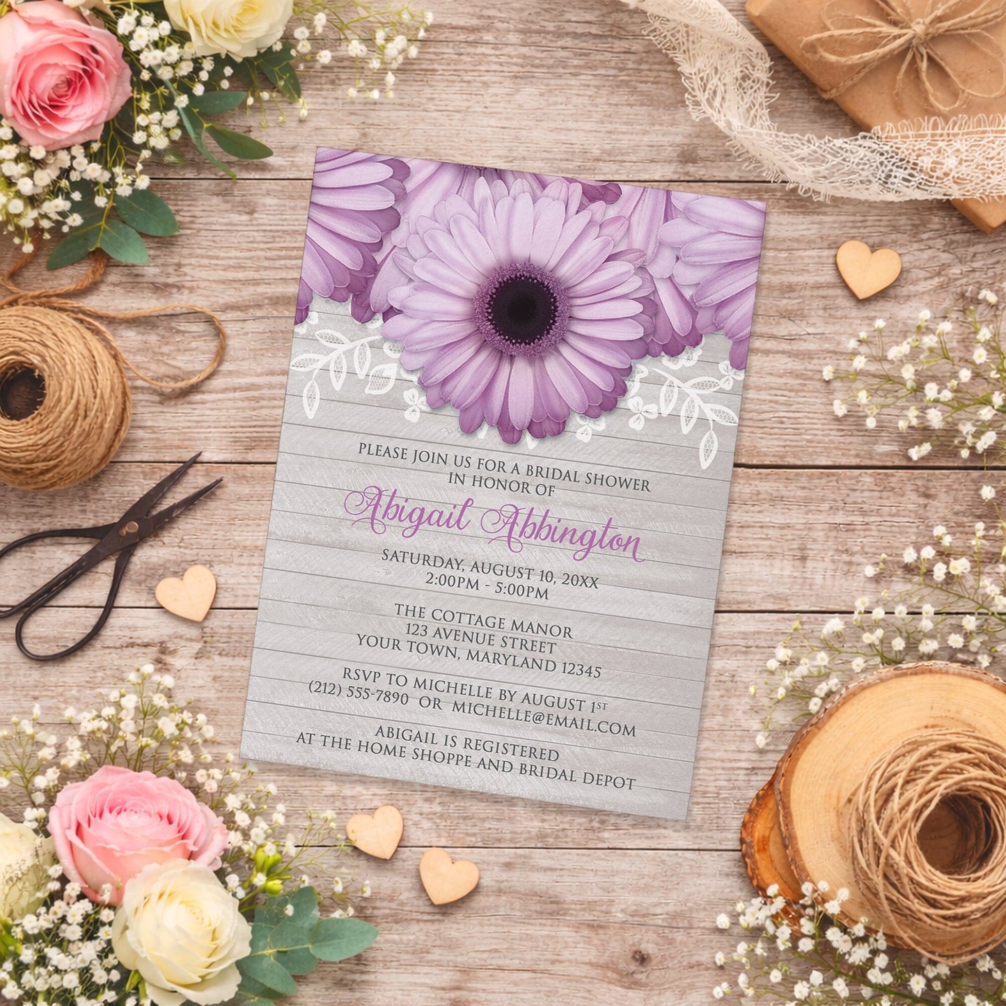 Rustic Purple Daisy Gray Wood Bridal Shower Invitation on a wooden surface with spring and summer flowers and twine.
