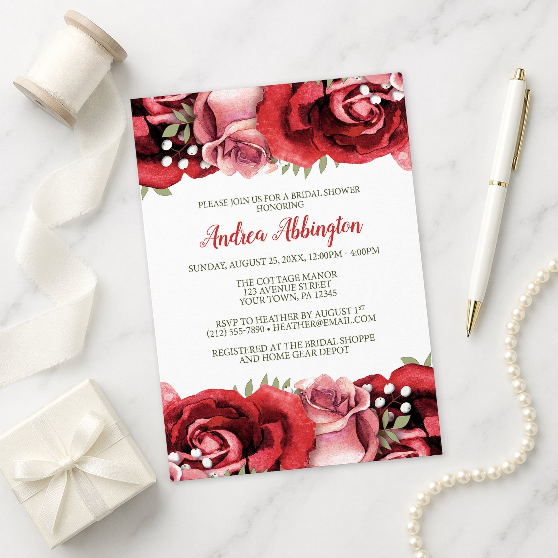 Rustic Red Pink Rose Green White Bridal Shower Invitation shown on a marble surface with a white gift box, pen, ribbon, and pearls.