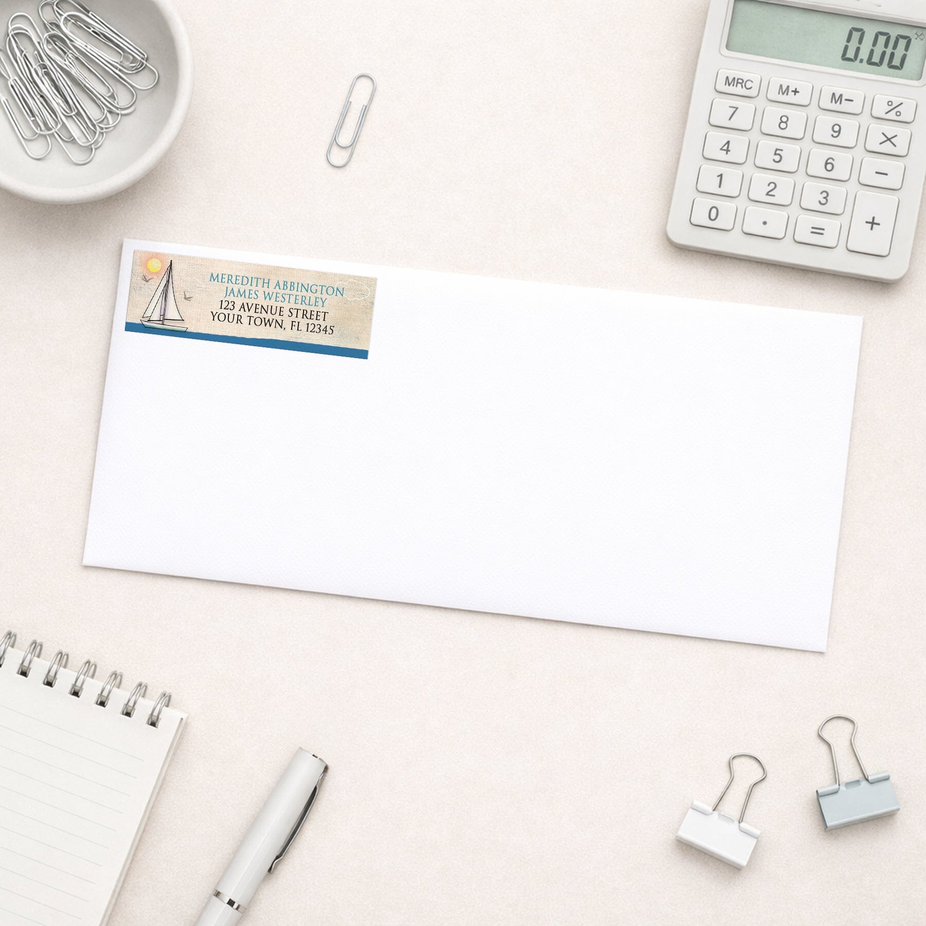 Rustic Sailboat Nautical Address Label shown on a white envelope with everyday office supplies