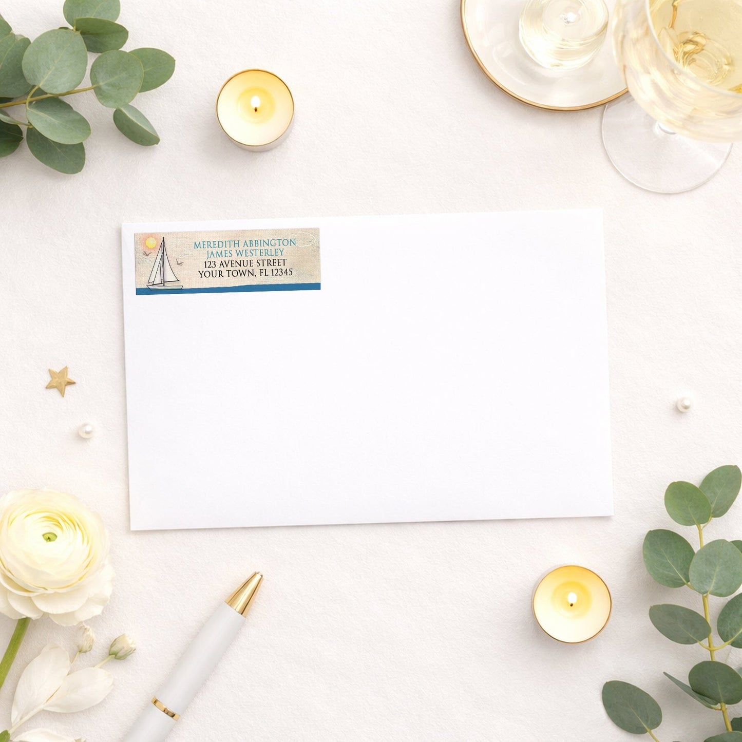 Rustic Sailboat Nautical Address Label shown on a white envelope with wedding and shower supplies