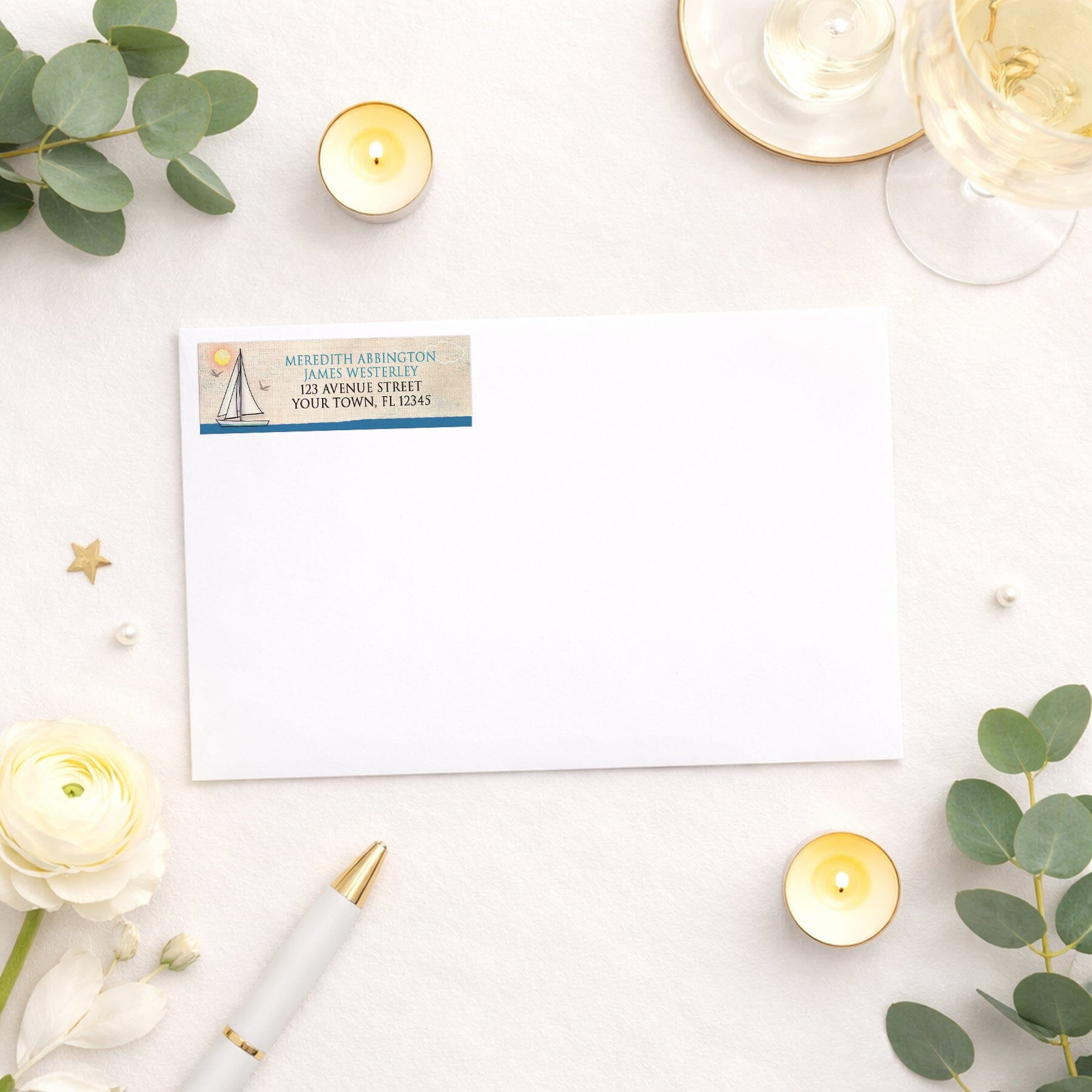 Rustic Sailboat Nautical Address Label shown on a white envelope with wedding and shower supplies
