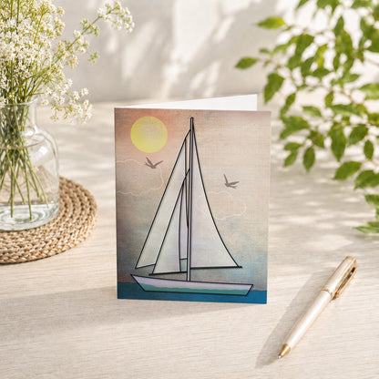 Rustic Sailboat Nautical Note Card shown on a tabletop with a vase, spring and summer flowers, and a pen.