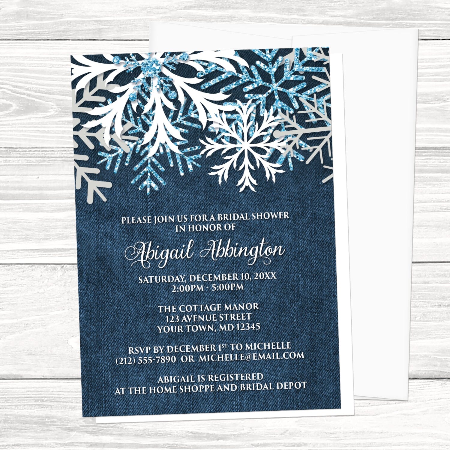 Rustic Snowflake Denim Winter Bridal Shower Invitation shown in a light wood surface with a white envelope.