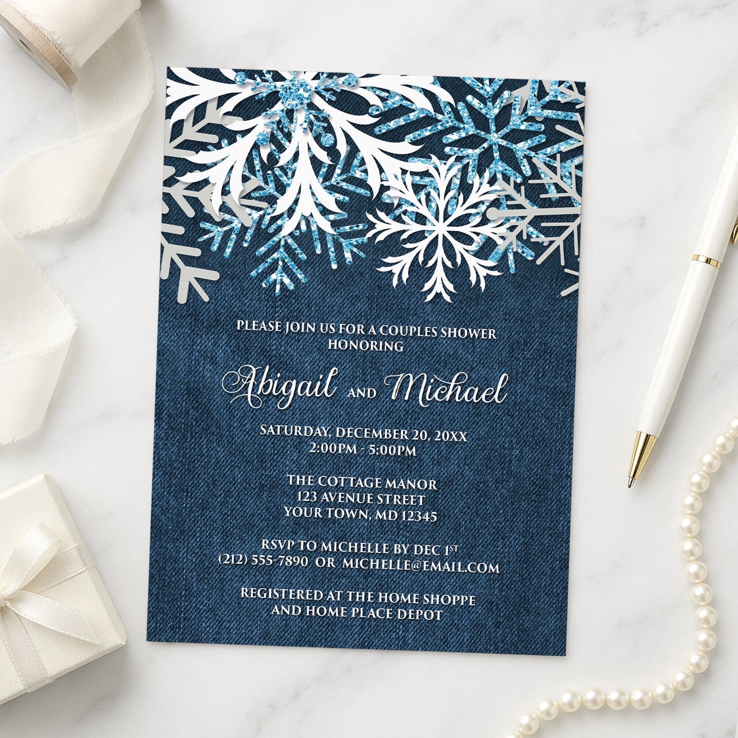Rustic Snowflake Denim Winter Couples Shower Invitation shown on a marble surface with a white gift box, pen, ribbon, and pearls.
