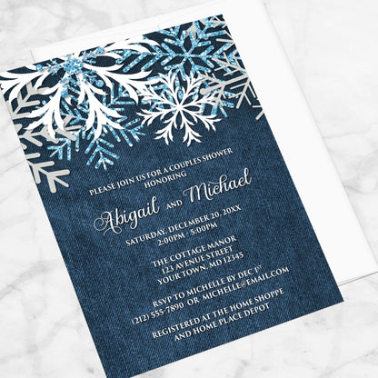 Rustic Snowflake Denim Winter Couples Shower Invitation shown at an angle on a marble surface with a white envelope.