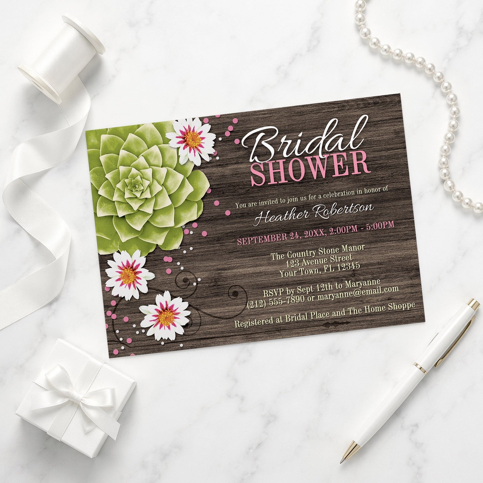 Rustic Succulent Floral Bridal Shower Invitation on a marble surface with elegant decorative items.