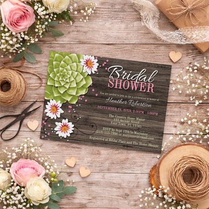 Rustic Succulent Floral Bridal Shower Invitation on a wooden surface with flowers, twine, and wooden hearts.