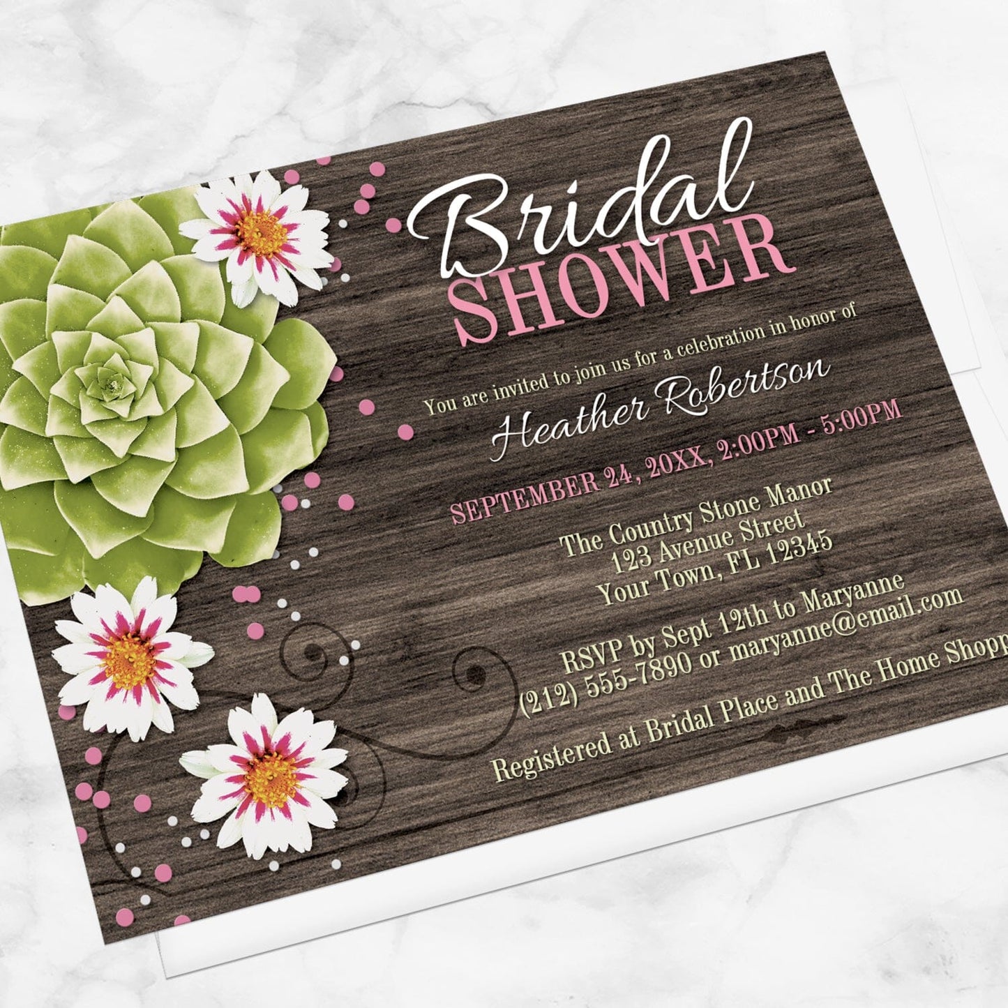 Rustic Succulent Floral Bridal Shower Invitation shown at an angle on a marble surface.