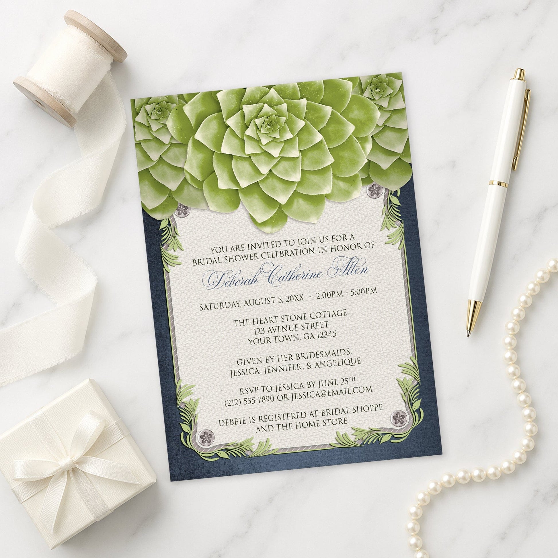 Rustic Succulent Garden Navy Bridal Shower Invitation on a marble surface with a white gift box, ribbon, pen, and pearls.