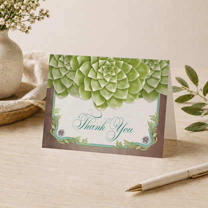 Rustic Succulent Garden Thank You Card shown on a desk with a vase, plants, and a pen.