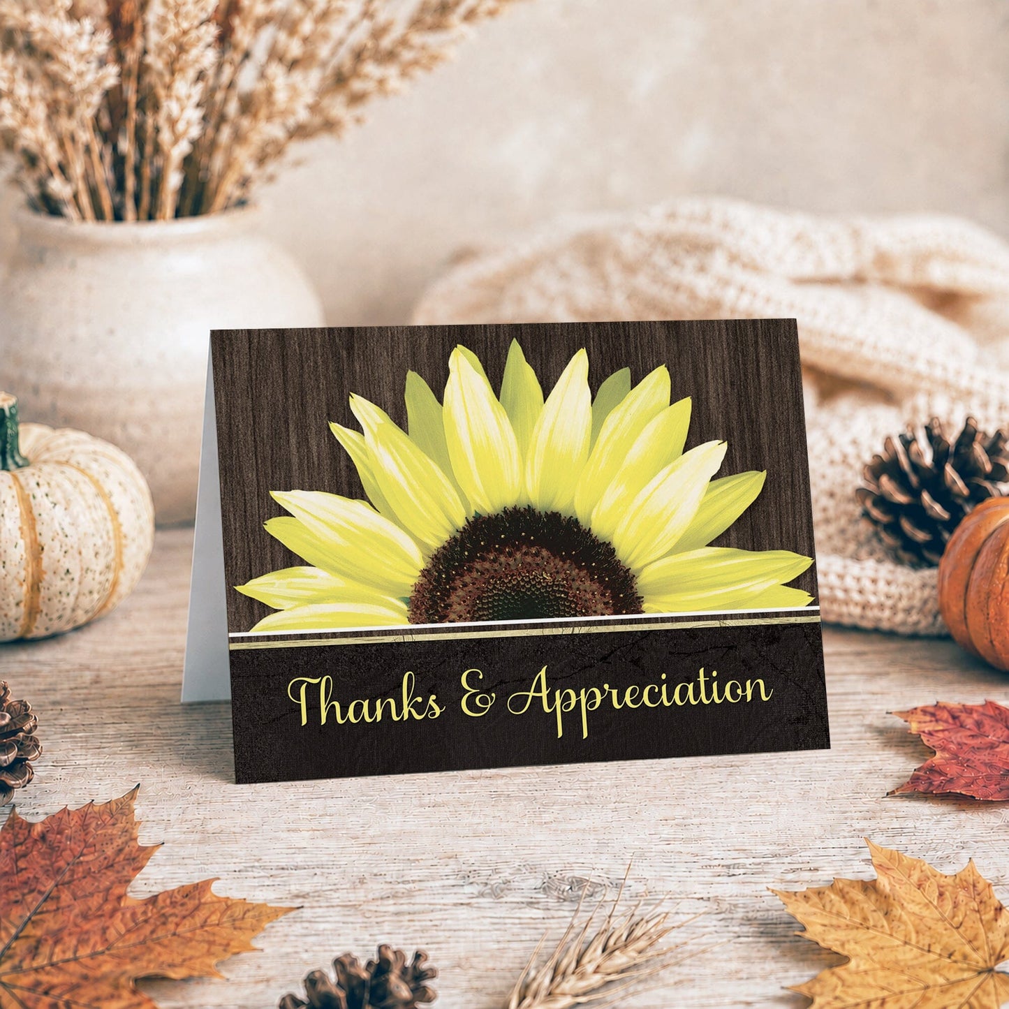 Rustic Sunflower Black Thank You Card shown on a tabletop with fall leaves and autumn decor.