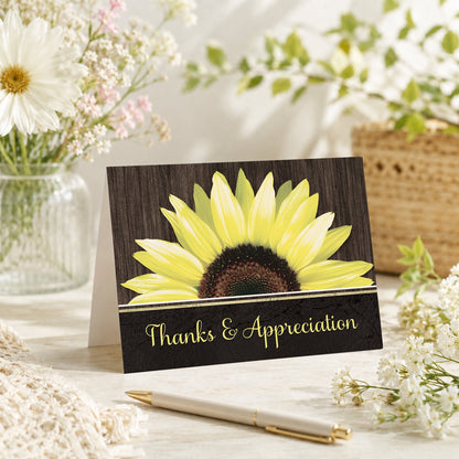 Rustic Sunflower Black Thank You Card shown on a tabletop with a vase, summer flowers, and a pen.