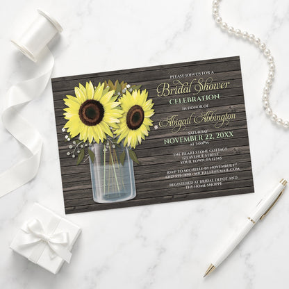 Rustic Sunflower Wood Mason Jar Bridal Shower Invitation on a marble surface with wedding shower items.