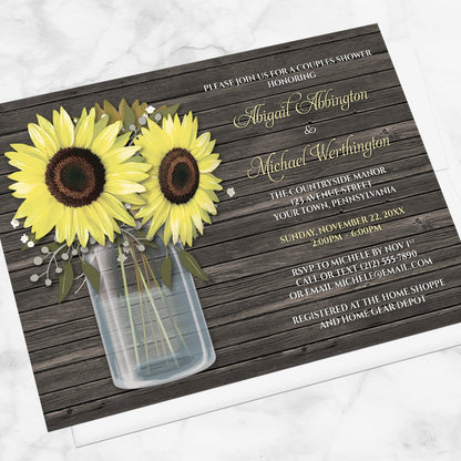 Rustic Sunflower Wood Mason Jar Couples Shower Invitation shown at an angle on a marble surface with a white envelope.