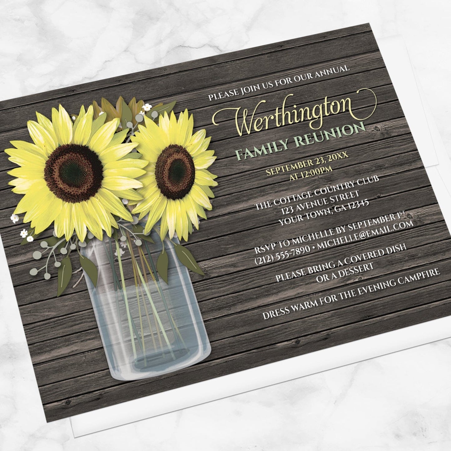 Rustic Sunflower Wood Mason Jar Family Reunion Invitation shown at an angle on a marble surface with a white envelope.