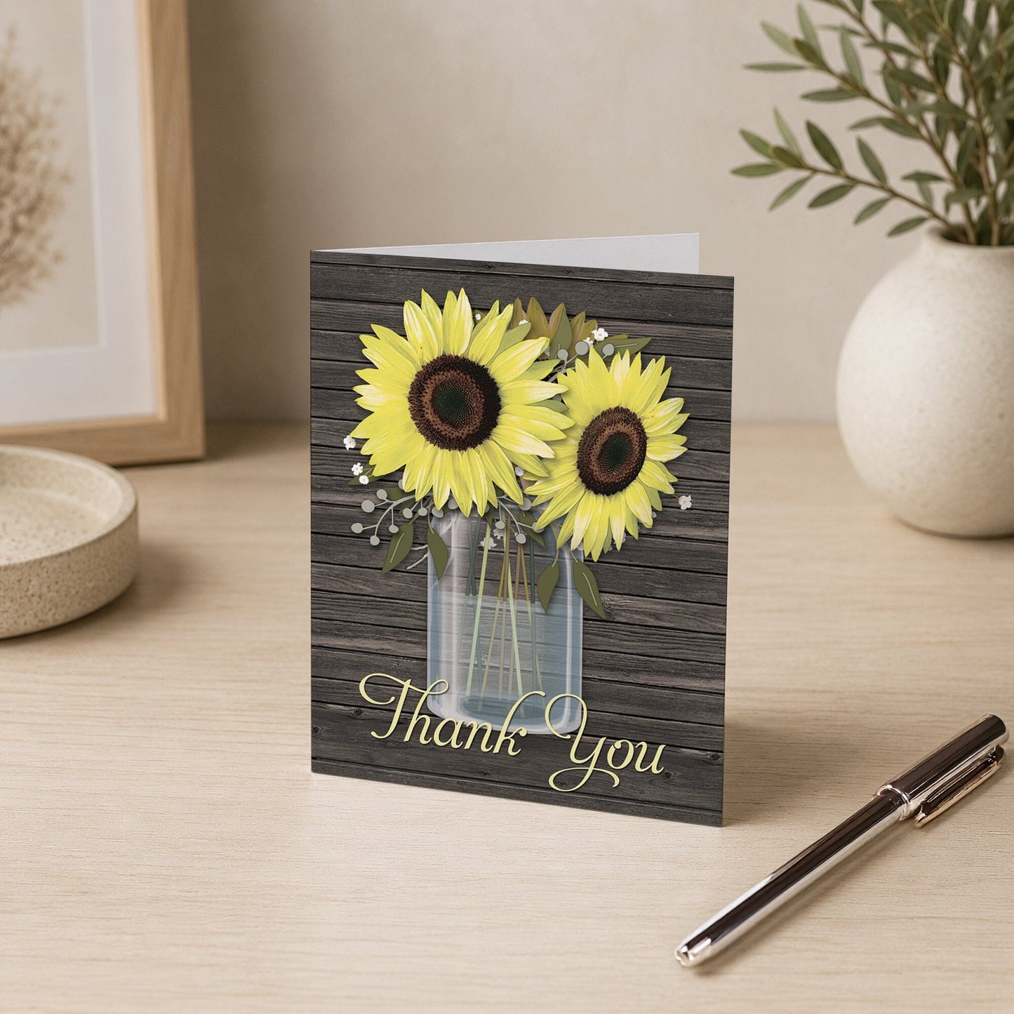 Rustic Sunflower Wood Mason Jar Thank You Card shown on a desk with a vase and a pen.