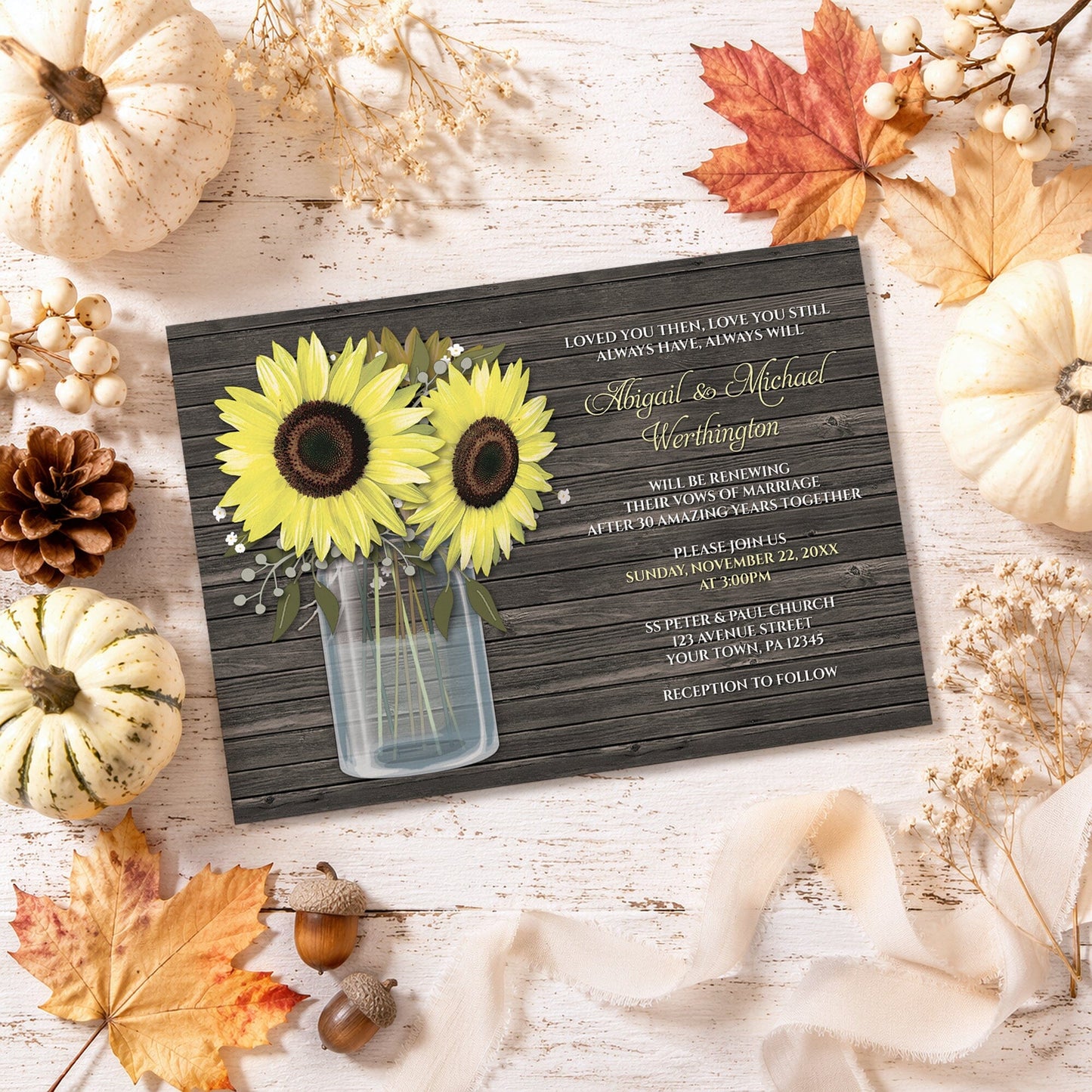 Rustic Sunflower Wood Mason Jar Vow Renewal Invitation shown on a light wooden surface with fall leaves and autumn decor.