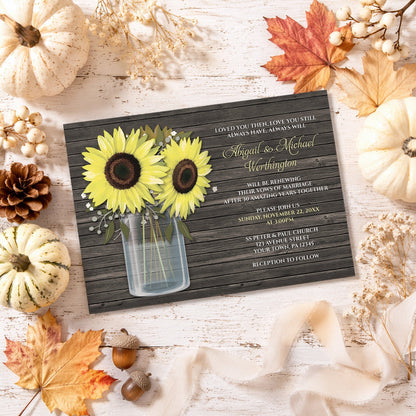 Rustic Sunflower Wood Mason Jar Vow Renewal Invitation shown on a light wooden surface with fall leaves and autumn decor.