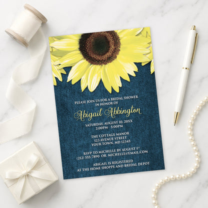 Rustic Sunflower and Denim Bridal Shower Invitation on a marble surface with a white gift box, ribbon, pen, and pearls.