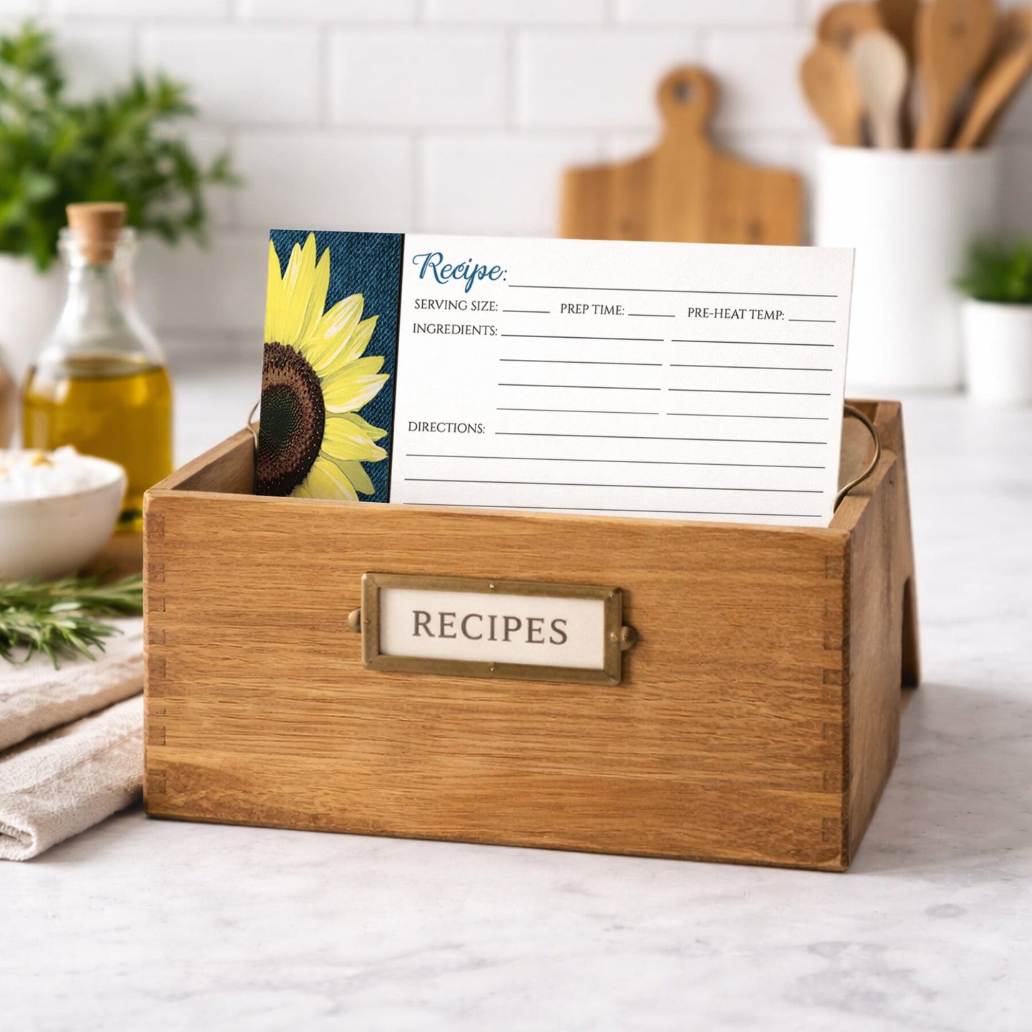 Wooden recipe box with a Rustic Sunflower and Denim Recipe Card on a kitchen counter.