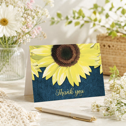 Rustic Sunflower and Denim Thank You Card shown on a tabletop with a vase, spring and summer flowers, and a pen.