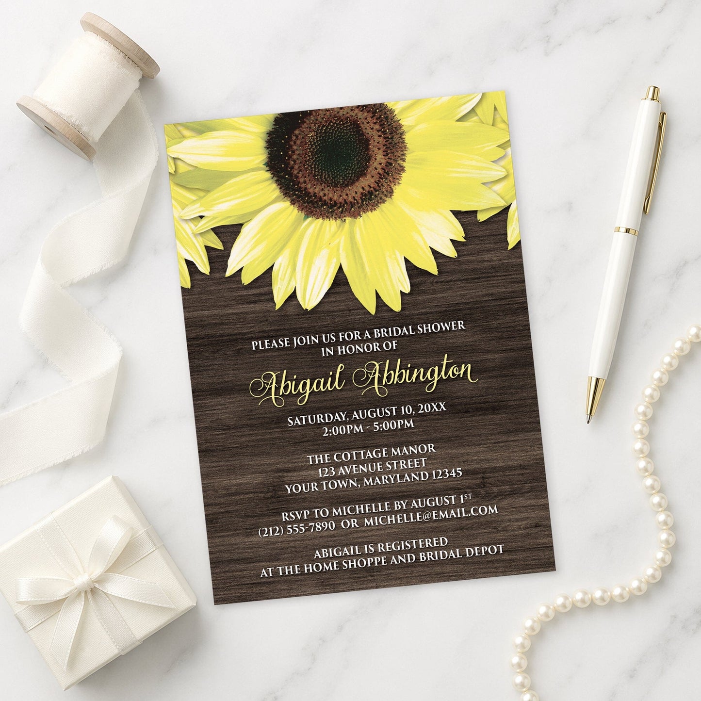 Rustic Sunflower and Wood Bridal Shower Invitation on a marble surface with a gift box and pen.