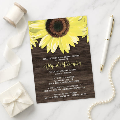 Rustic Sunflower and Wood Bridal Shower Invitation on a marble surface with a gift box and pen.