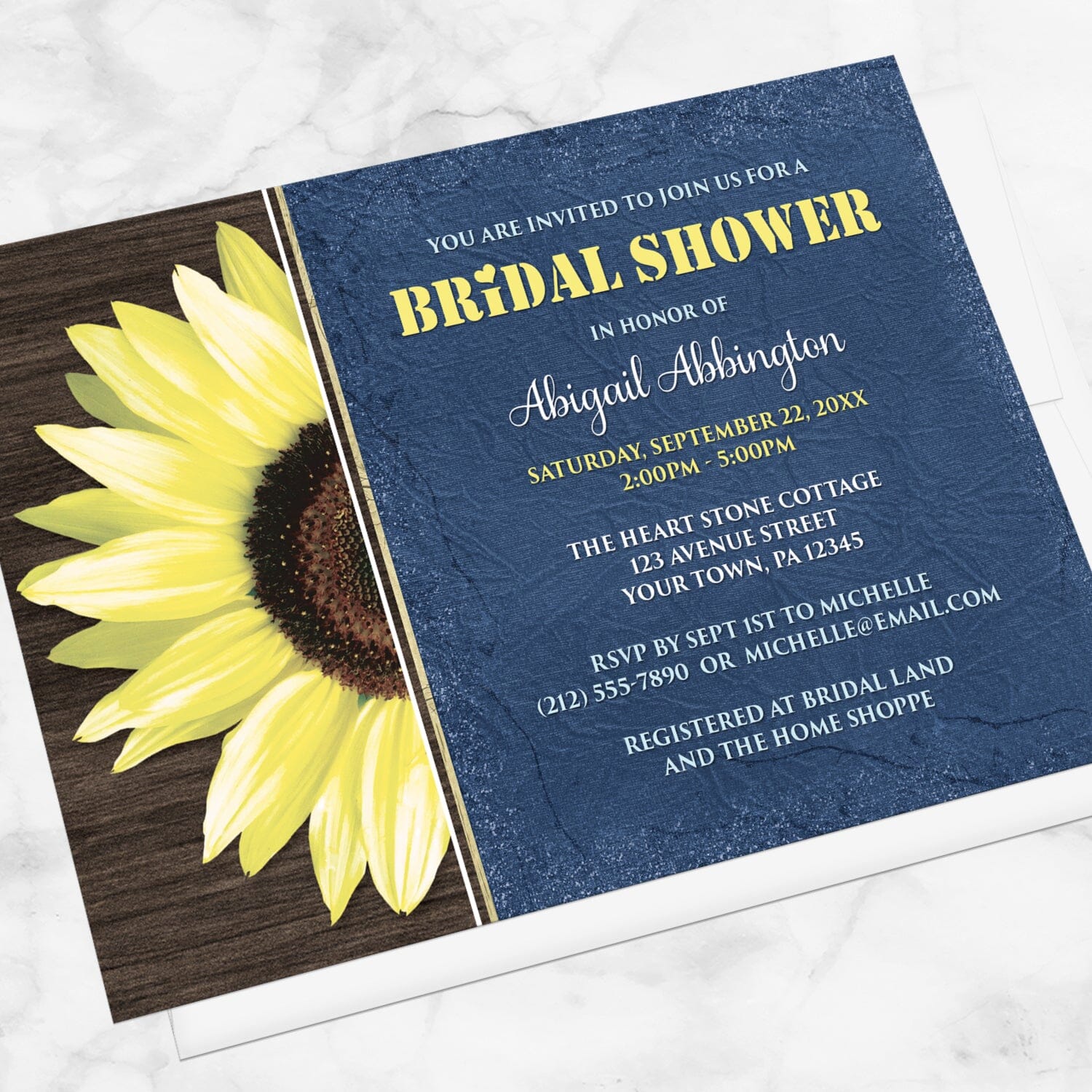 Rustic Sunflower with Blue Bridal Shower Invitation shown at an angle on a marble surface with a white envelope.