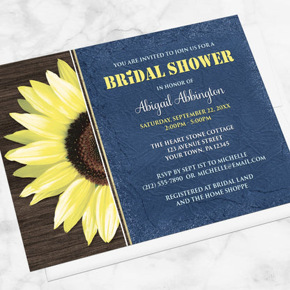 Rustic Sunflower with Blue Bridal Shower Invitation shown at an angle on a marble surface with a white envelope.