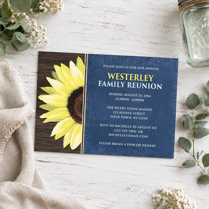 Rustic Sunflower with Blue Family Reunion Invitation shown on a light wooded surface with plants and a small mason jar.