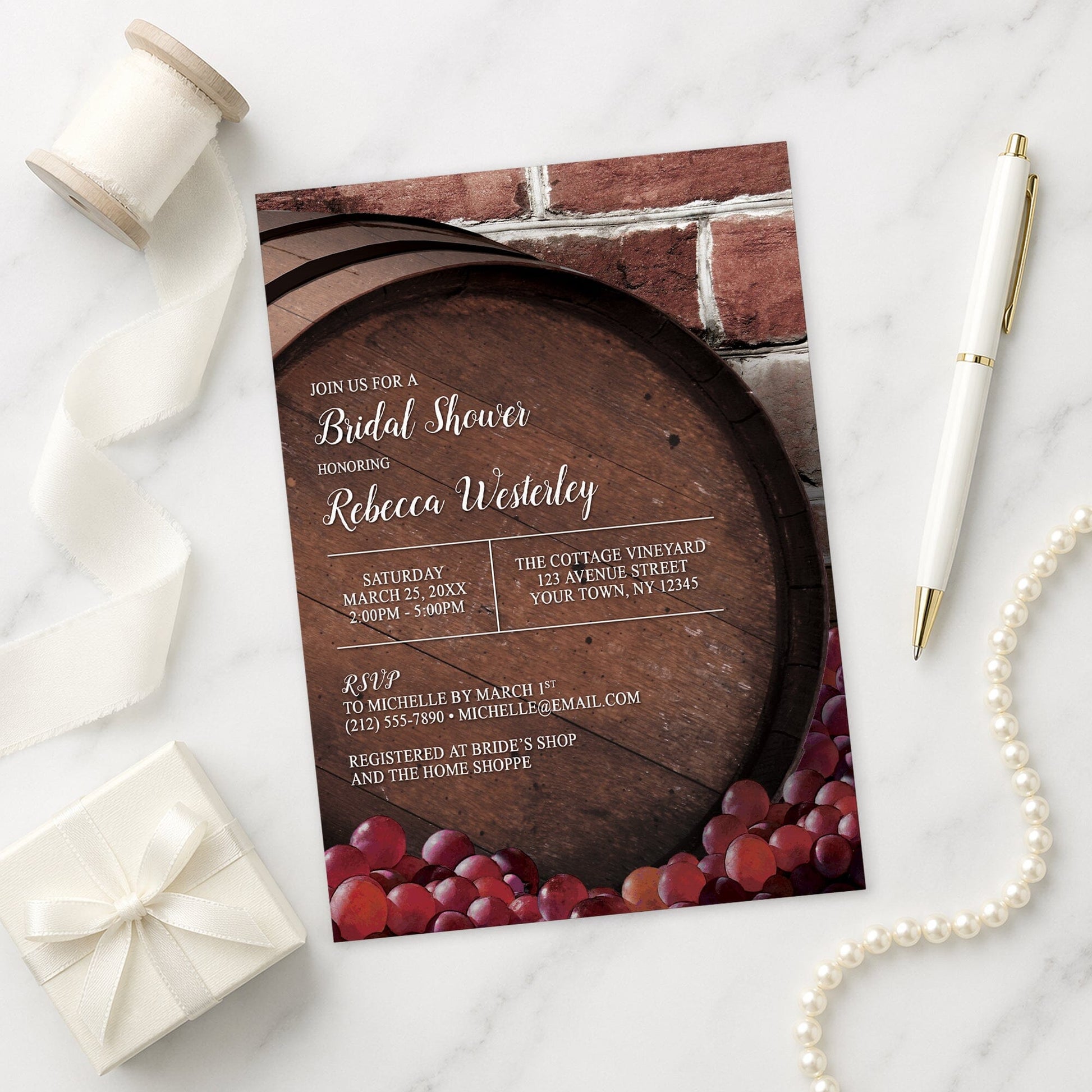Rustic Wine Barrel Vineyard Bridal Shower Invitation on a marble surface with decorative items.