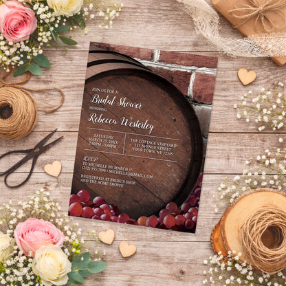 Rustic Wine Barrel Vineyard Bridal Shower Invitation on a wooden surface with flowers and twine.