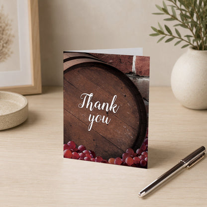 Rustic Wine Barrel Vineyard Thank You Card shown on a desk with a vase and a pen.