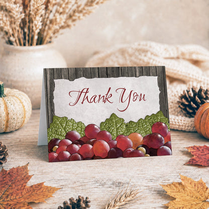 Rustic Winery Grapes Thank You Card shown on a tabletop with fall leaves and autumn decor.