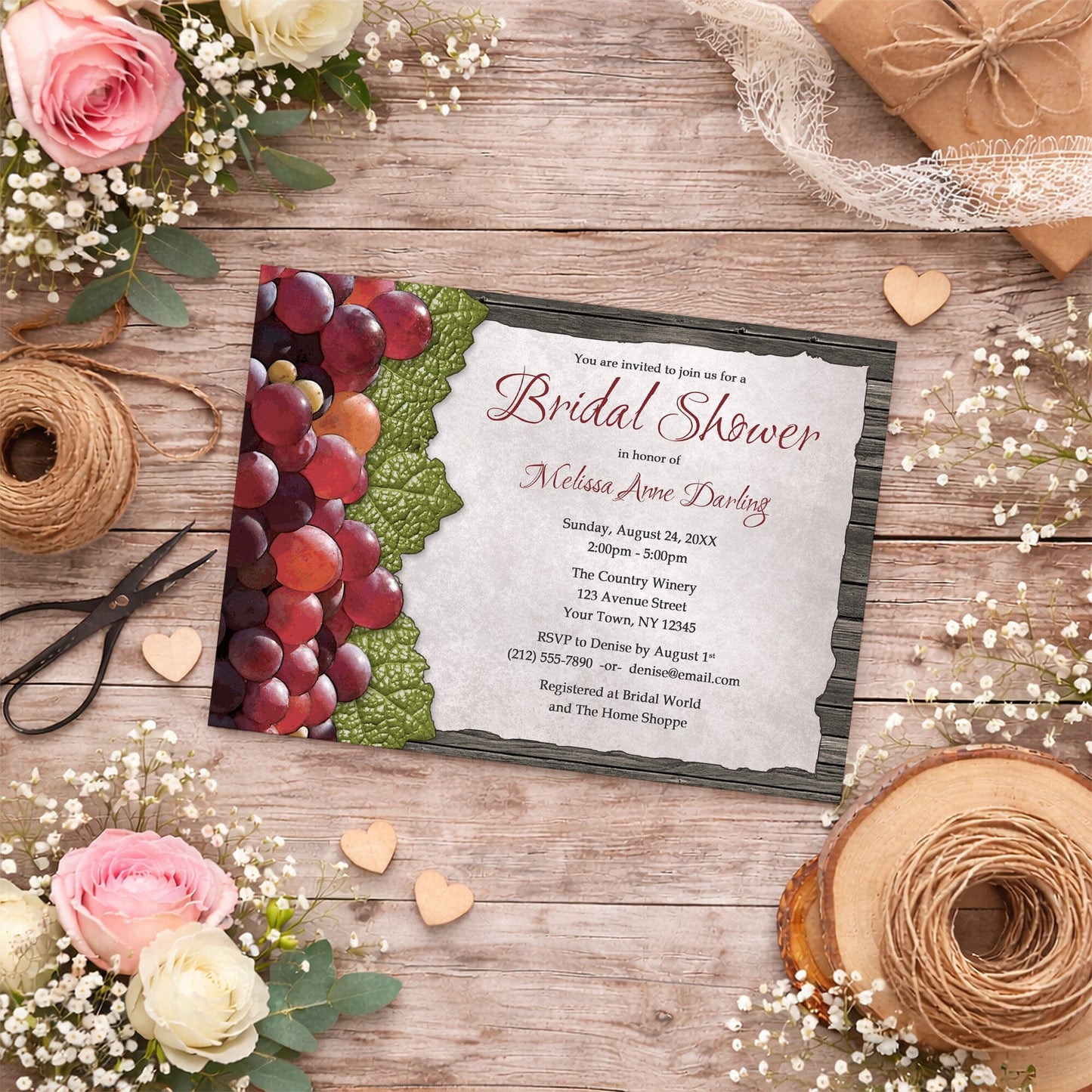 Rustic Winery Grapes and Wood Bridal Shower Invitation shown on a country-inspired wooden surface with spring and summer flowers, small wood hearts, lace ribbon, and twine.