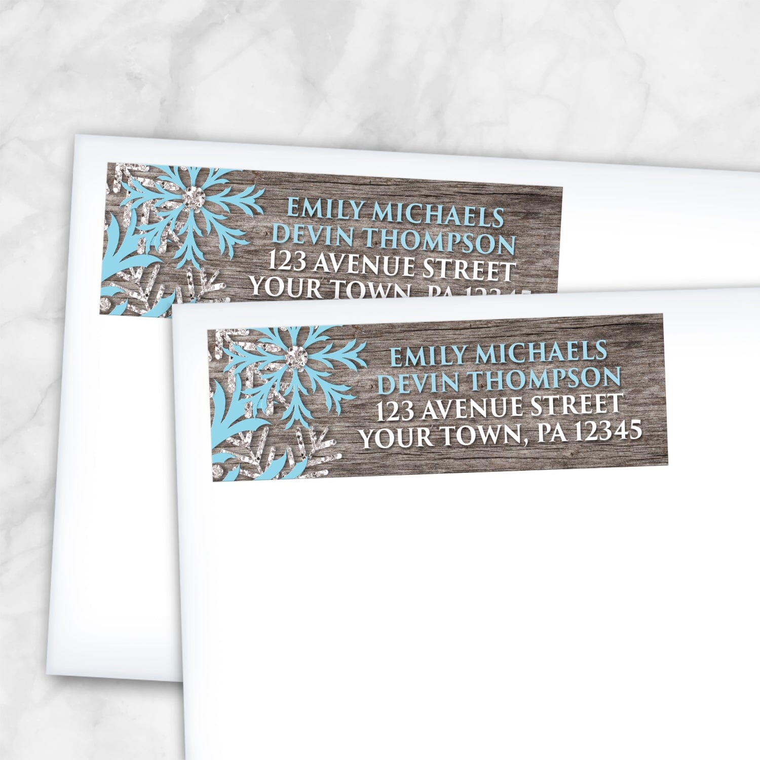 2 Rustic Winter Wood Blue Snowflake Address Labels shown on white envelopes on a marble surface