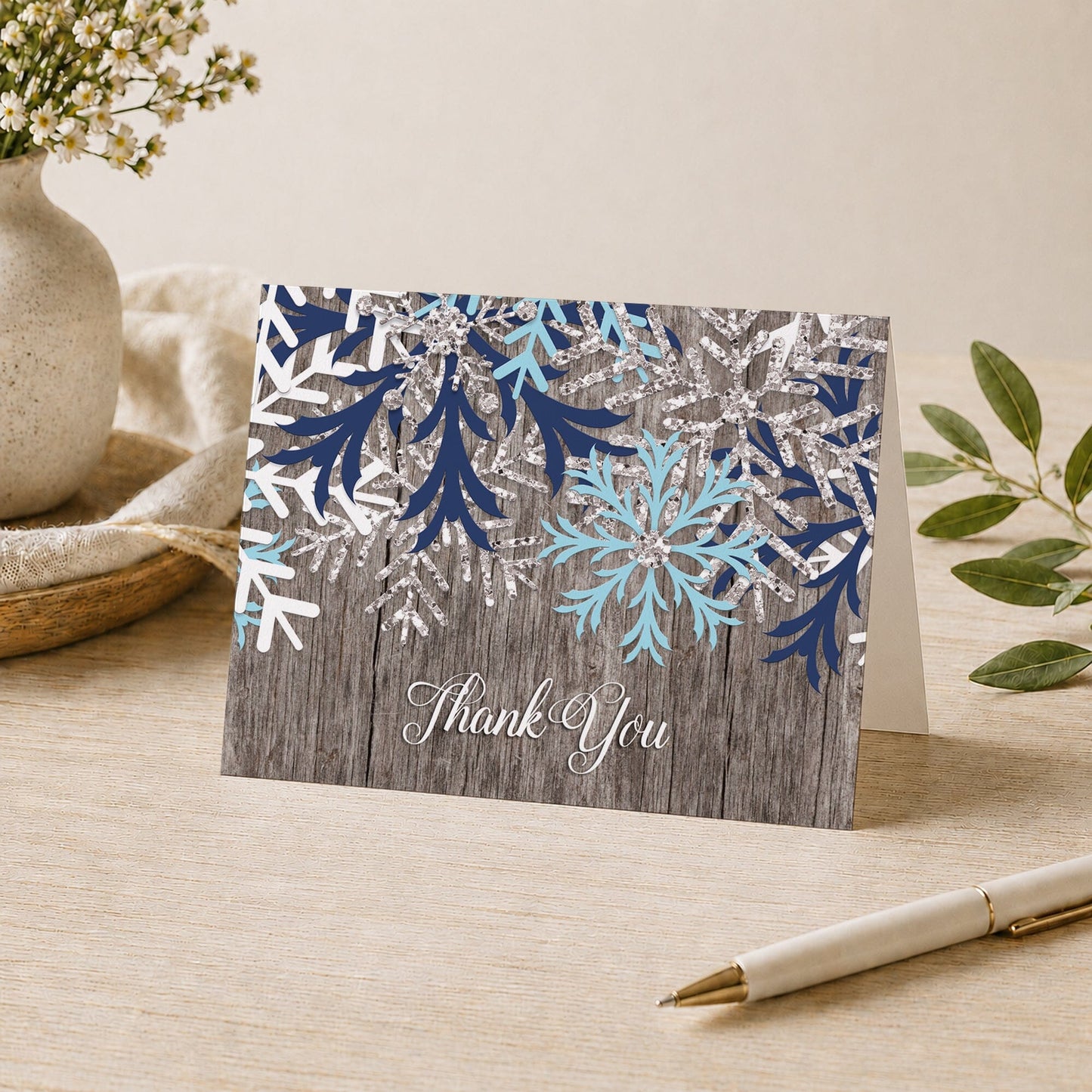 Rustic Winter Wood Navy Aqua Snowflake Thank You Card on a desk with a vase, plants, and a pen.