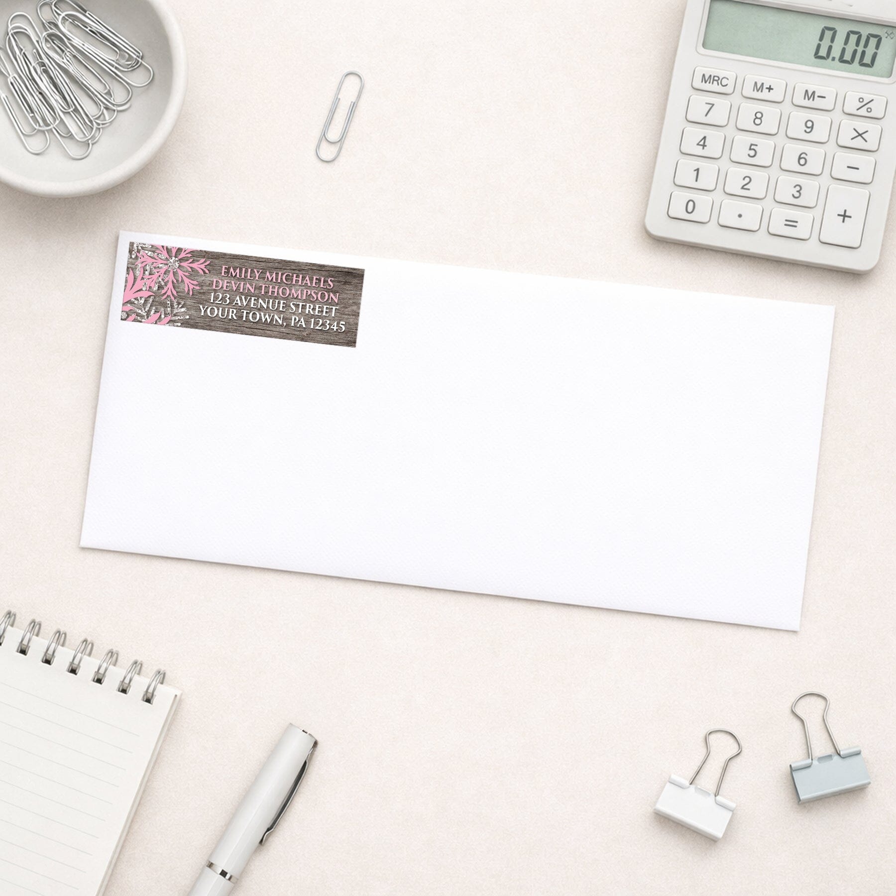 Rustic Winter Wood Pink Snowflake Address Label shown on a white envelope with everyday office supplies