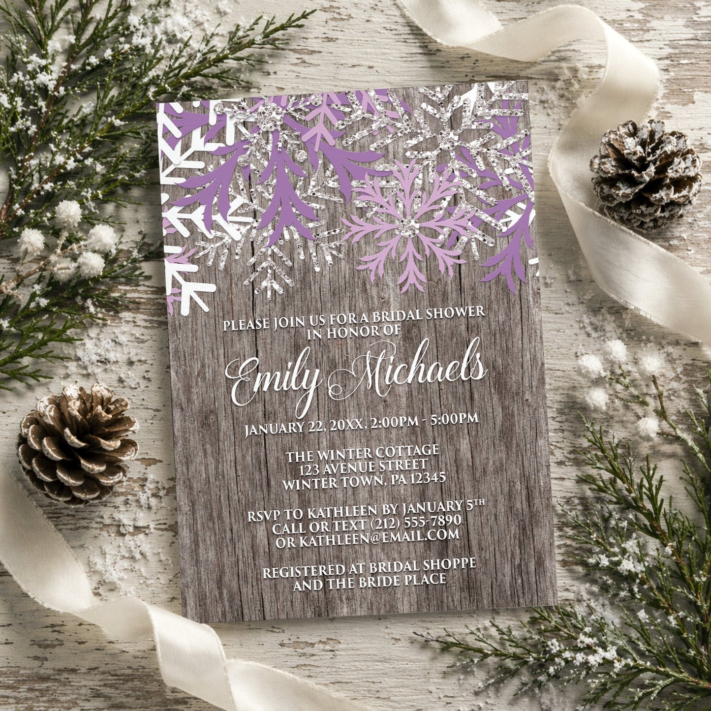 Rustic Winter Wood Purple Snowflake Bridal Shower Invitation surrounded by winter decorations.