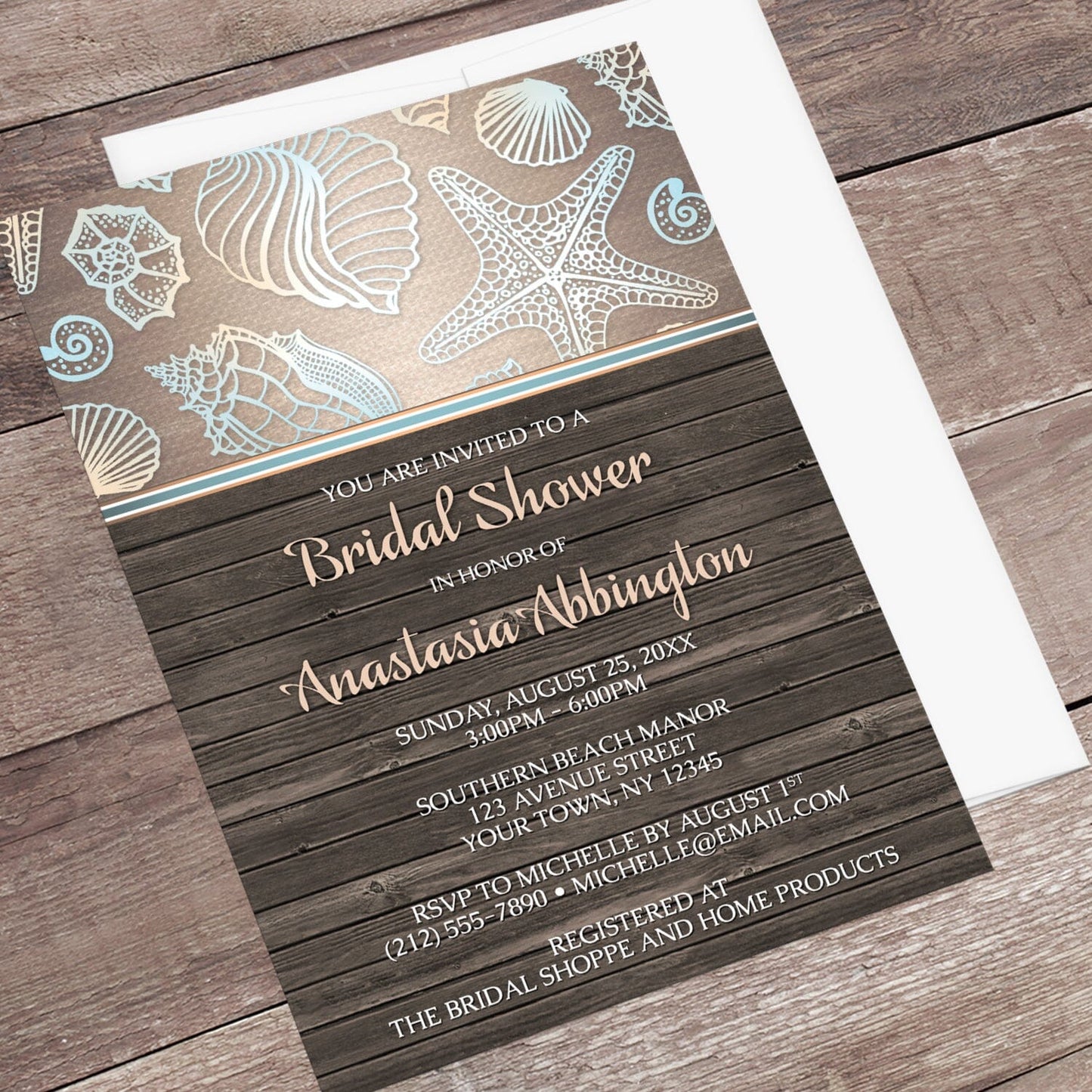 Rustic Wood Beach Seashell Bridal Shower Invitation shown at an angle on a wooden surface with a white envelope.