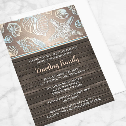 Rustic Wood Beach Seashell Family Reunion Invitation shown at an angle on a marble surface with a white envelope.