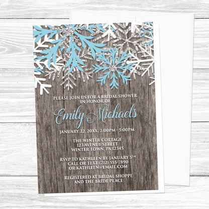 Rustic Winter Wood Blue Snowflake Bridal Shower Invitation shown on a light wood surface with a white envelope.
