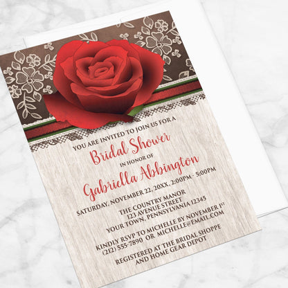 Bridal shower invitation with a large red rose, rustic wood, and illustrated lace, displayed at an angle with a white envelope on a marble surface