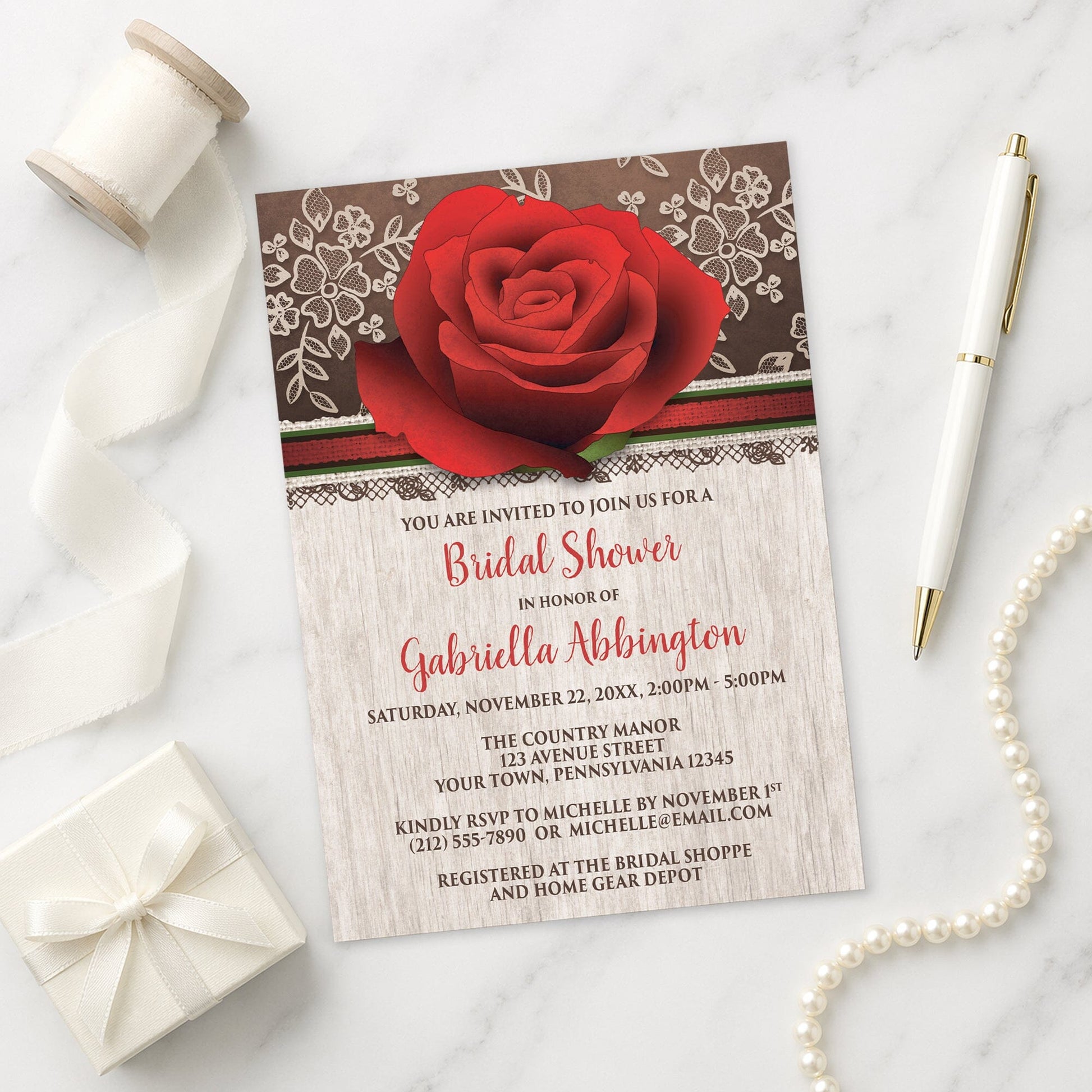 Rustic Wood Lace Red Rose Bridal Shower Invitation on a marble surface with a gift box, pen, ribbon, and pearls.